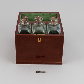 A late Empire mahogany box with three glass bottles, mid 19th Century.