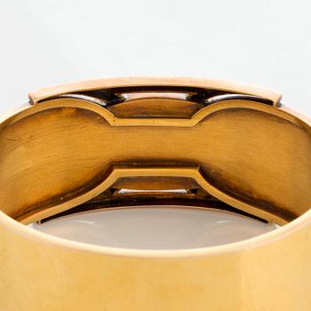 A 14K gold bangle set with a cabochon-cut garnet.