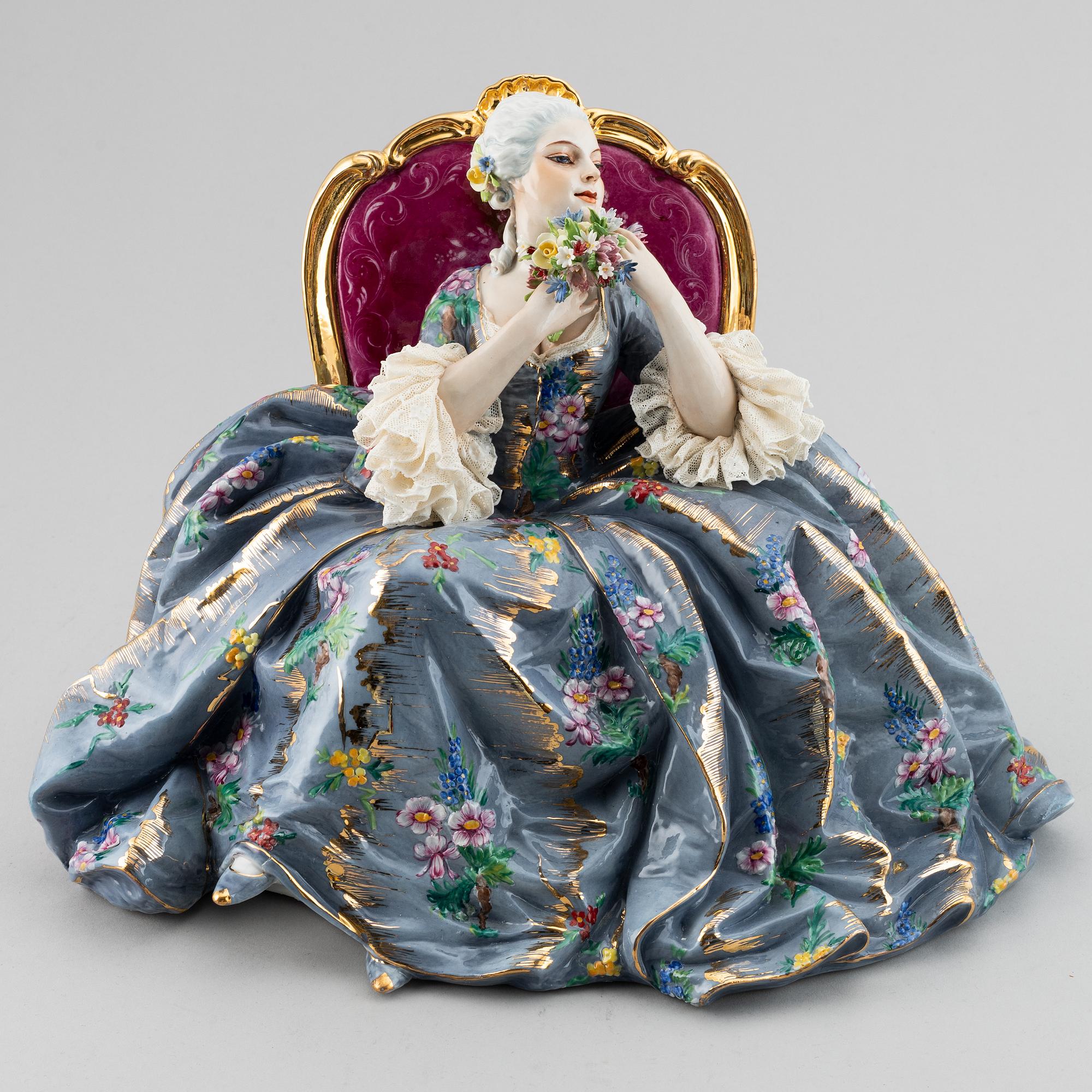 A porcelain figurine of a seated Rococo lady, 20th century, Italy.