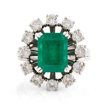 An emerald and round brilliant cut diamond ring.