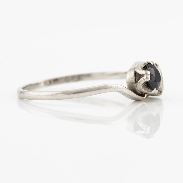 Ring, sibling ring, platinum with brilliant-cut diamond and dark sapphire.