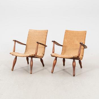 A pair of Swedish Modern pine and saddle-girth easy chairs from the 1940's.