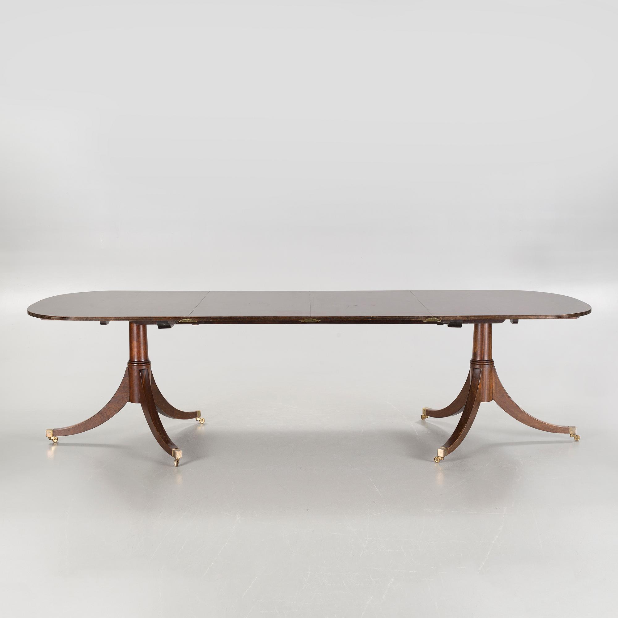 An english style dining table and eight chairs, second half of the 20th century.