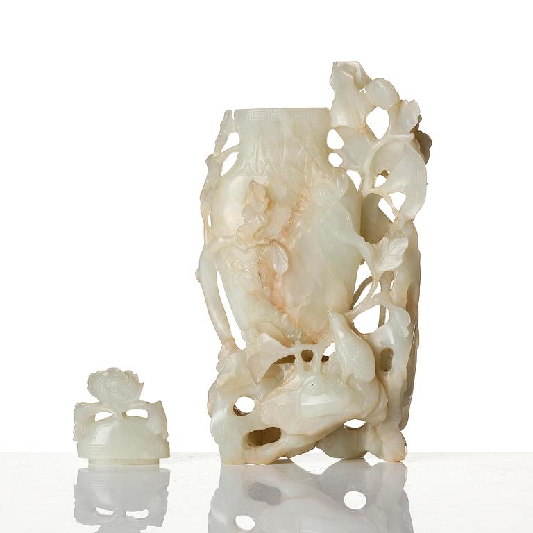 A well sculptured pale green and russet coloured nephrite vase with cover, 20th century.