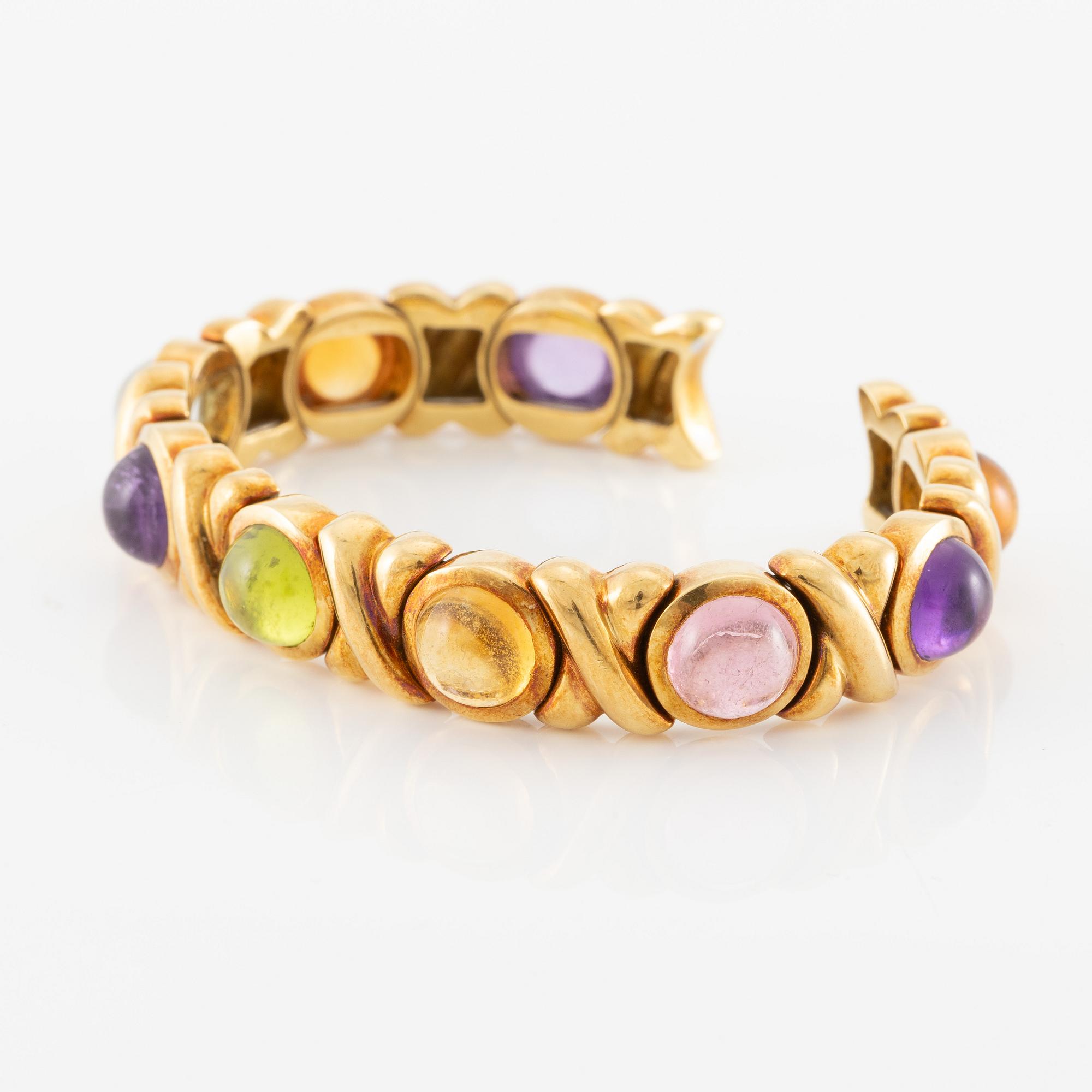 Bracelet in 18K gold set with cabochon-cut citrine, amethyst, pink tourmaline, peridot, and aquamarine.