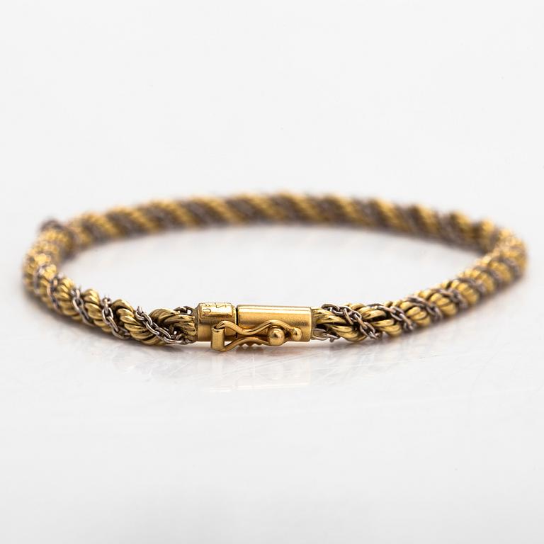 An 18K gold/white gold twisted bracelet. Foreign hallmark.