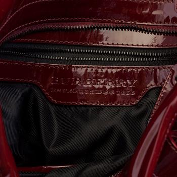 A darkred lacquer leather handbag by Burberry Prorsum.