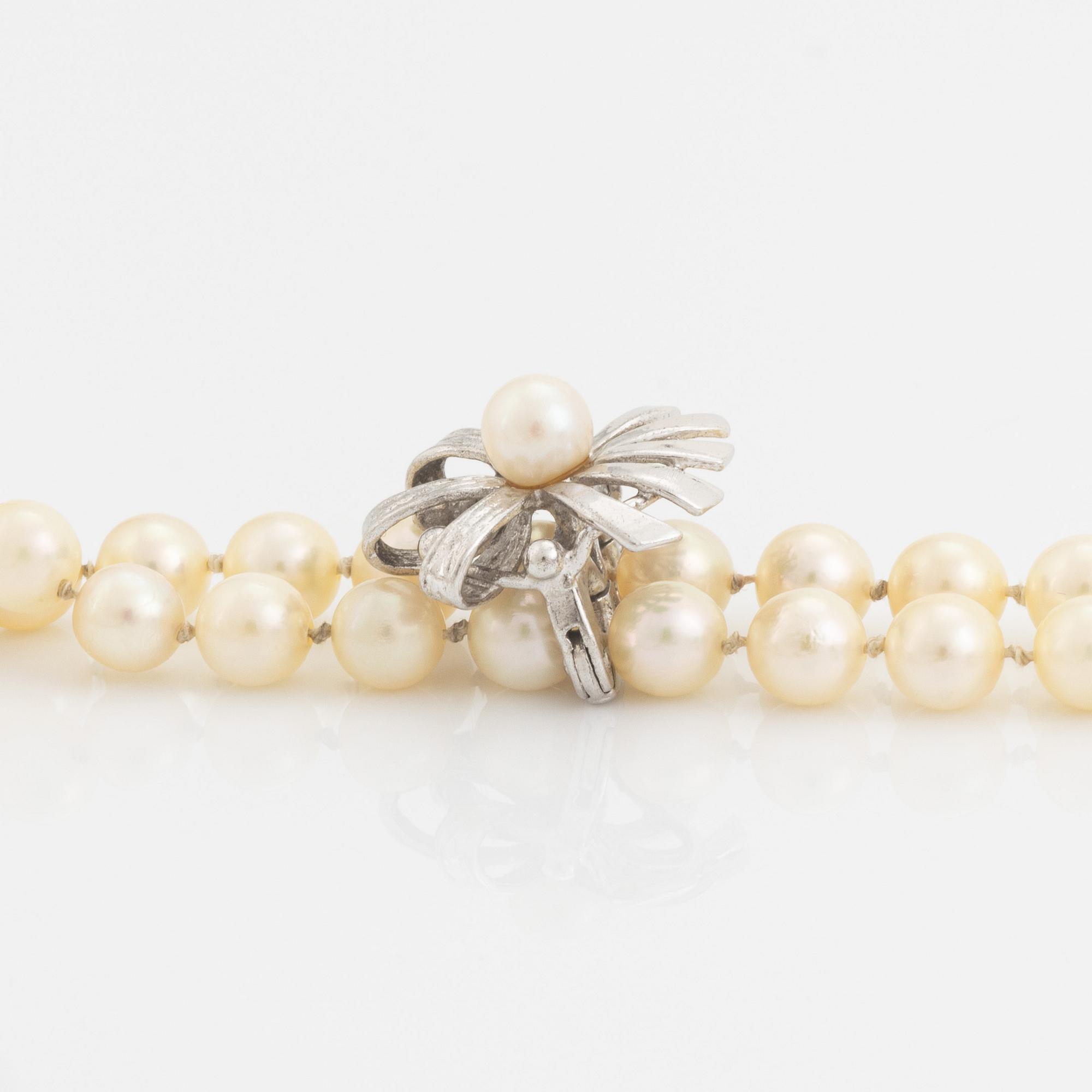 A cultured pearl necklace with silver divider.