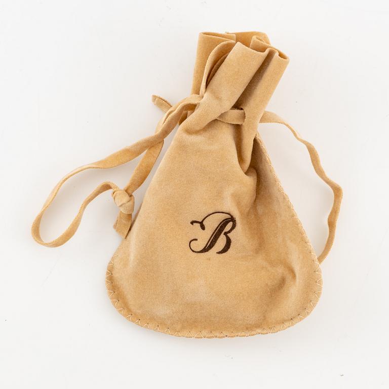 A brooch in platinum in the form of a bow with rubies and diamonds, likely from the 1950s.