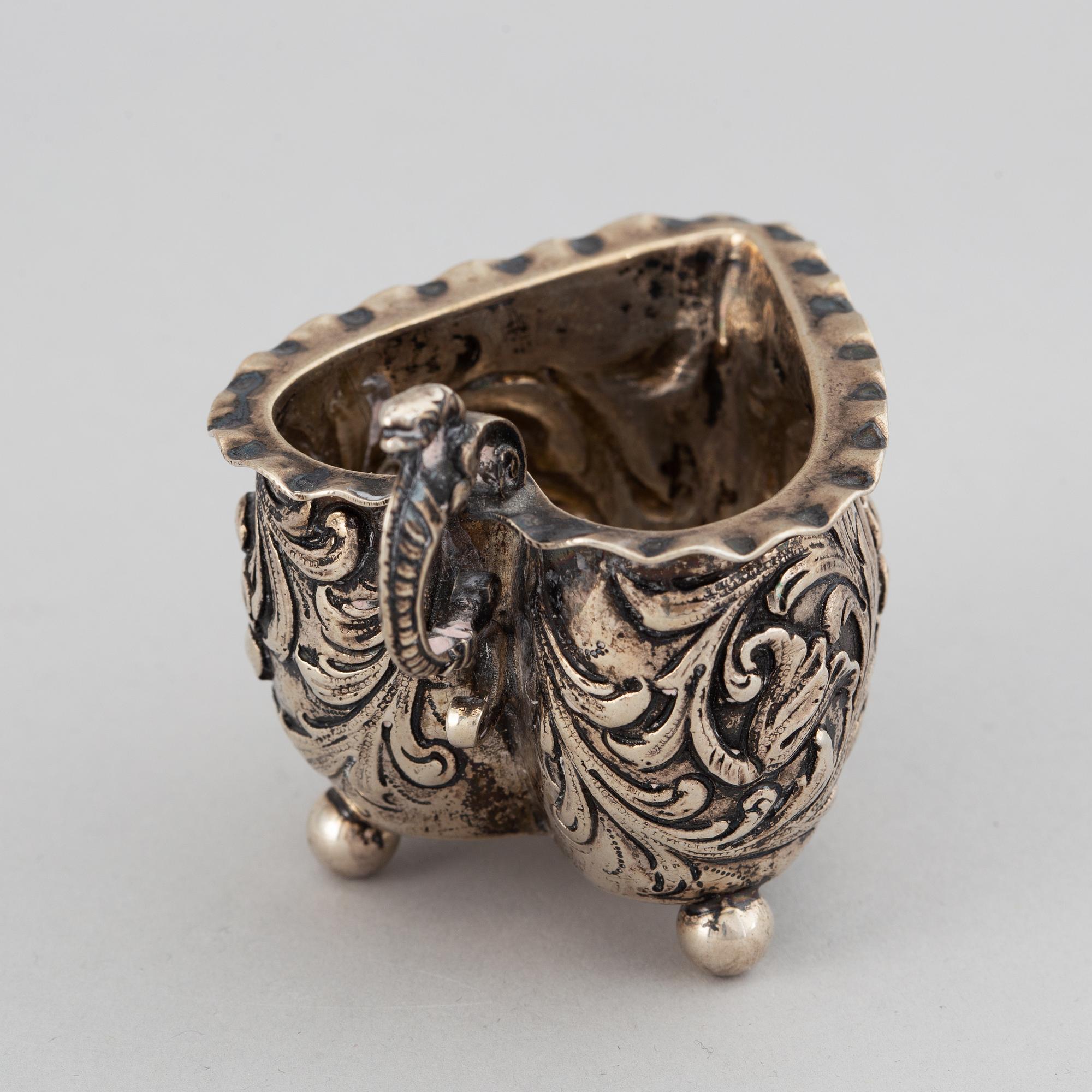 A small silver Baroque style  heart-shaped jug on ball feet.