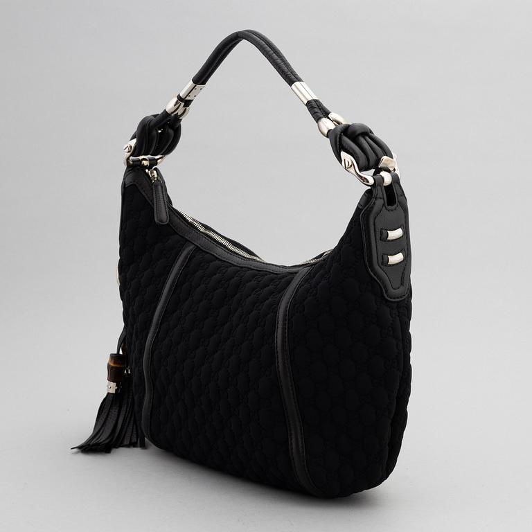 Gucci, a black neoprene handbag.