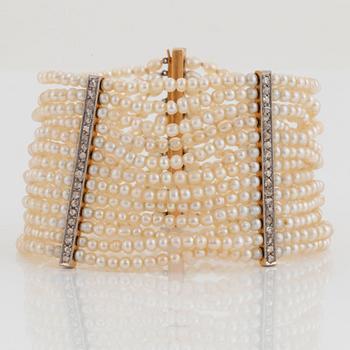 A pearl bracelet with a clasp and dividers in 14K gold and platinum set with rose-cut diamonds.