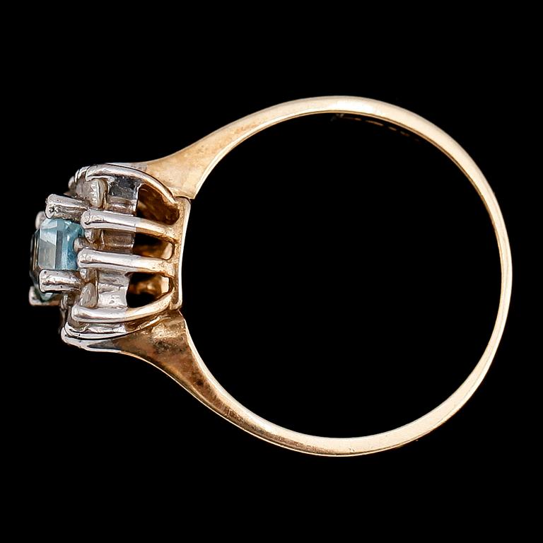 RING, 9 k guld med ljusblå fasetterad sten omgiven av vita stenar.