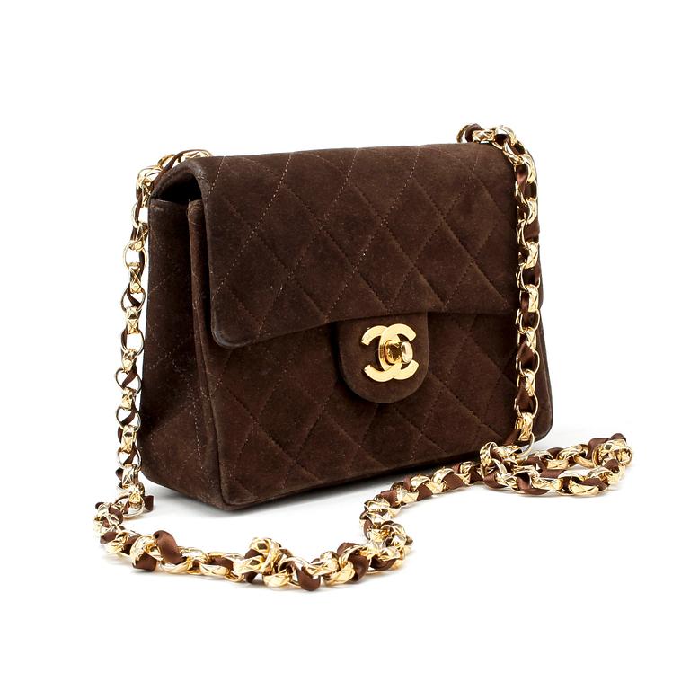 CHANEL, a brown suede quilted purse with shoulder strap.