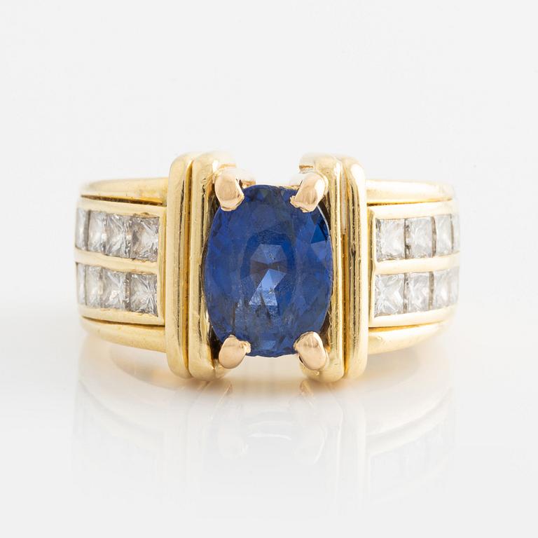 Ring in 18K gold set with an oval faceted sapphire and princess-cut diamonds.