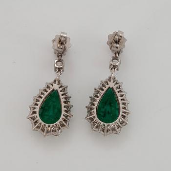 A pair of drop shaped faceted emerald and round brilliant-cut diamond earrings in 18K white gold.