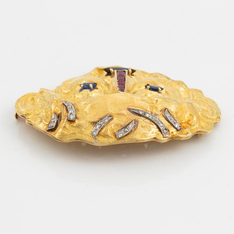 An 18K gold brooch set with diamonds and colored stones.