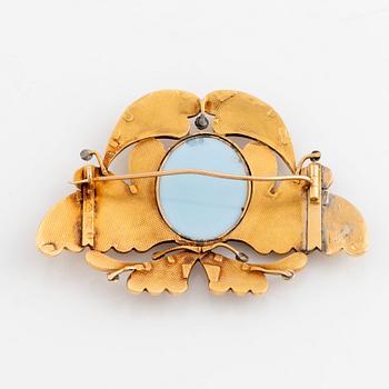 An 18K gold brooch set with a hard stone cameo.