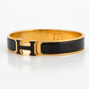 Black enamel and golden bracelet "Clic H" by Hermès.