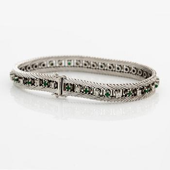 Bracelet 18K gold with round brilliant-cut diamonds and green stones, likely emeralds.