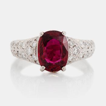 497. A platinum ring set with a faceted ruby and round brilliant-cut diamonds.