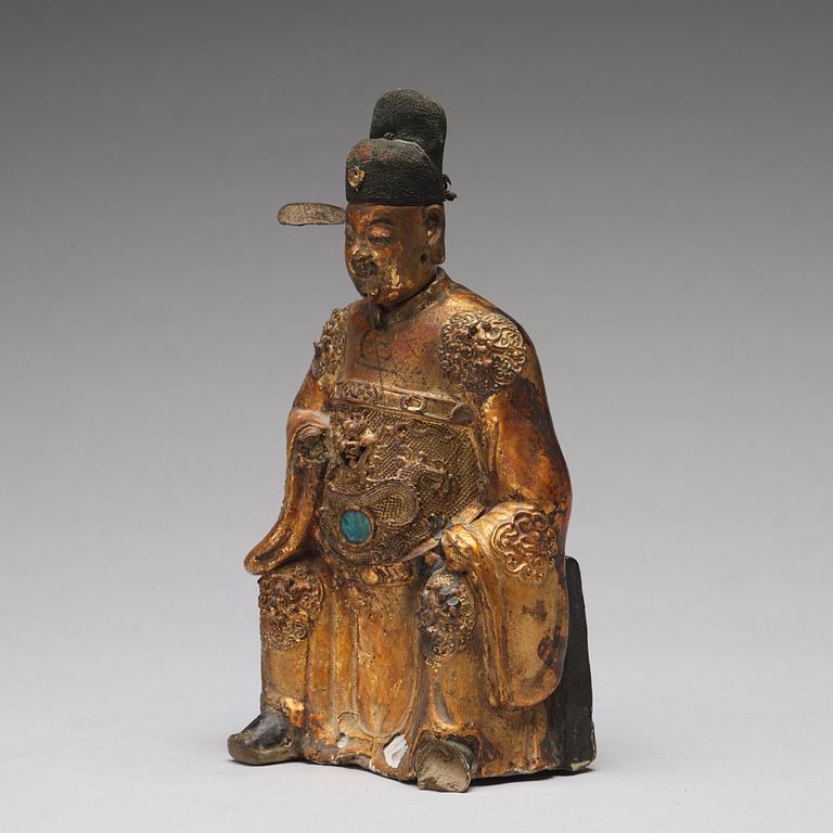 A lacquered and gilt ceramic sculpture of a deity, Ming dynasty (1368-1644).