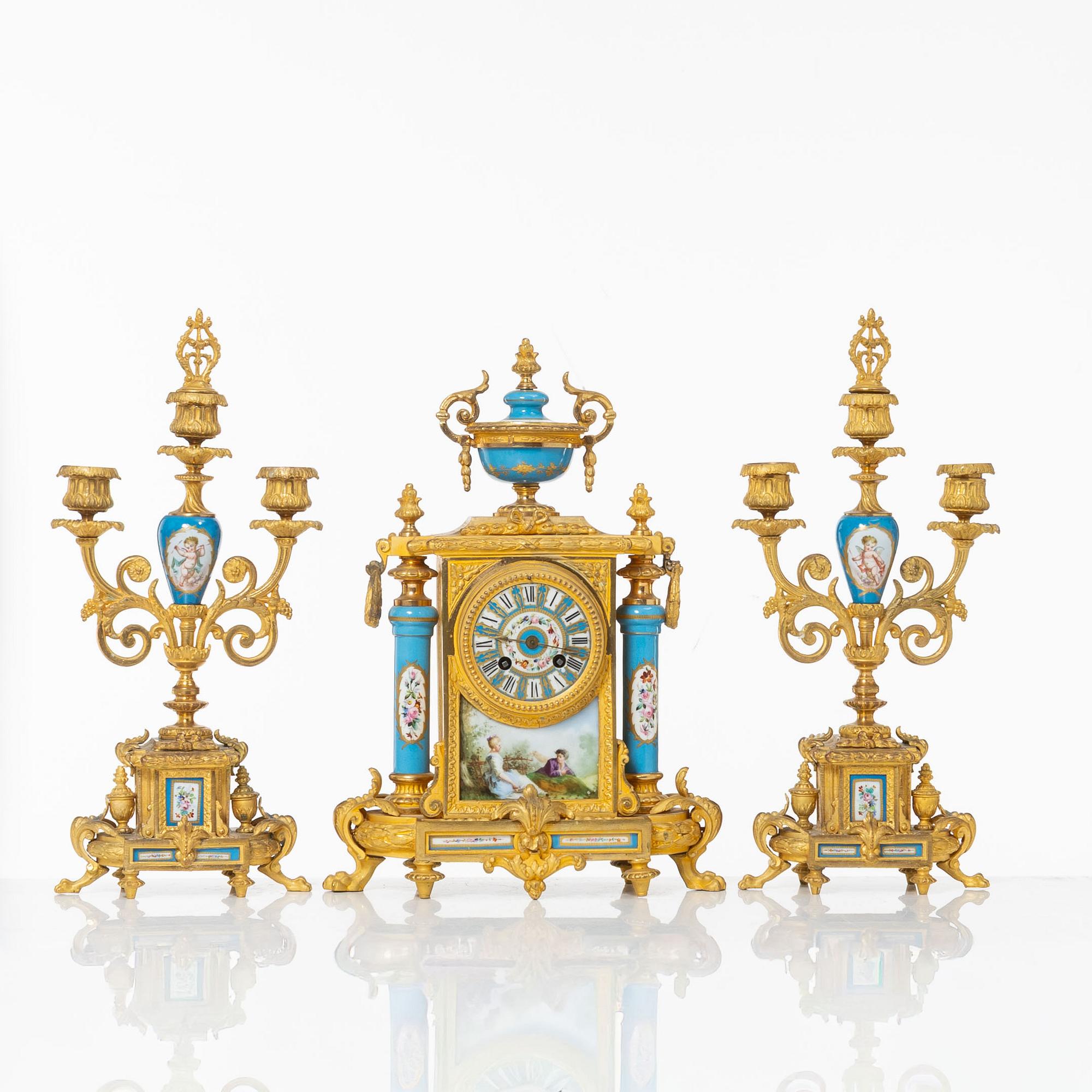 A French Louis XVI-style mantel clock and a pair of candelabra, late 19th Century.