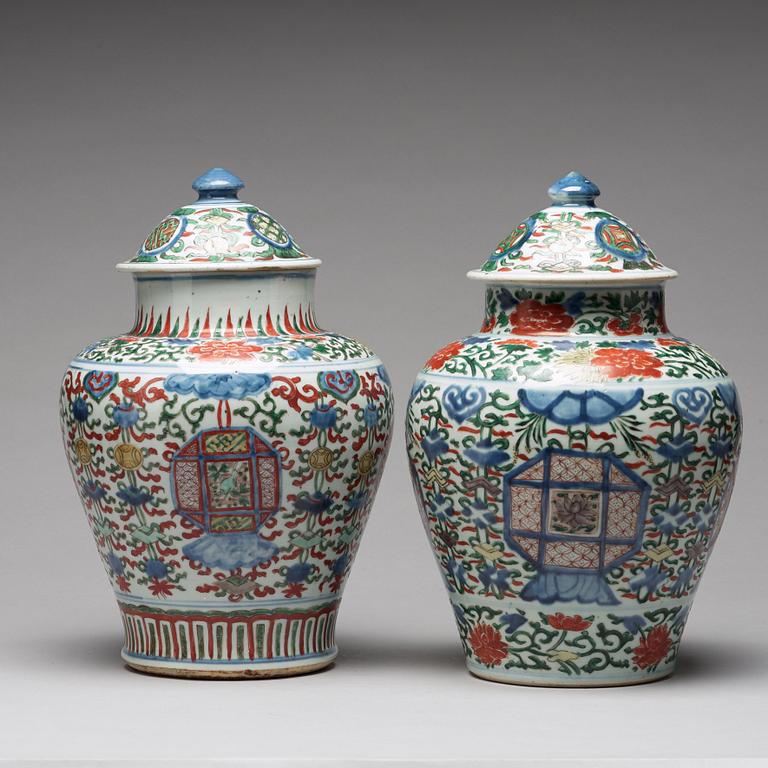 A matched pair of Transitional wucai baluster vases with covers, 17th Century.