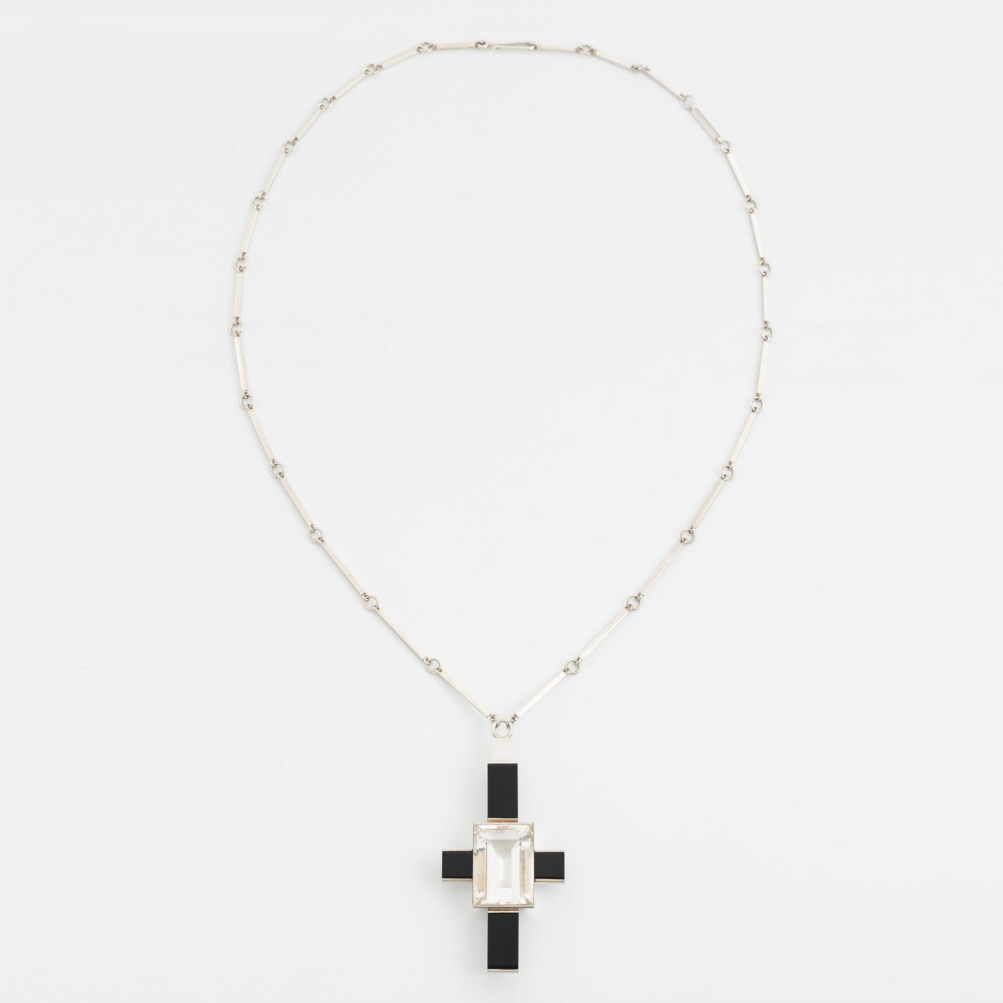 Wiwen Nilsson, hängsmycke i form av ett kors i sterlingsilver med fasettslipad bergkristall och onyx, Lund 1939.