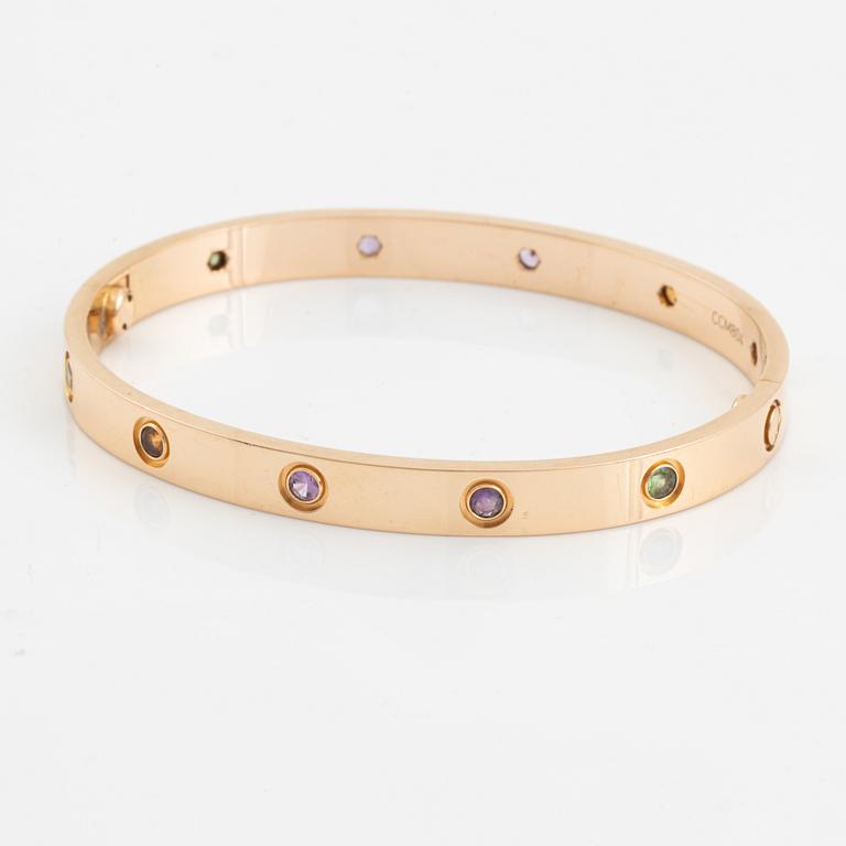 A Cartier "Love" bracelet in 18K rose gold set with colored stones.