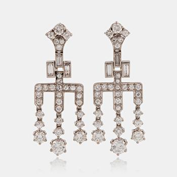 959. A pair of earrings set with round brilliant- and baguette-cut diamonds.