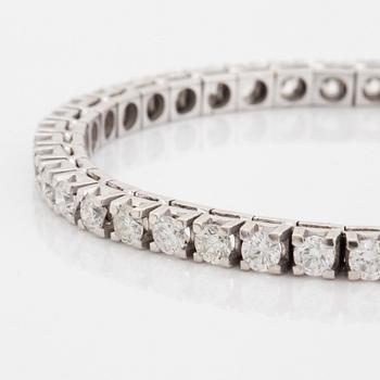 A tennis bracelet in 18K gold set with round brilliant-cut diamonds.