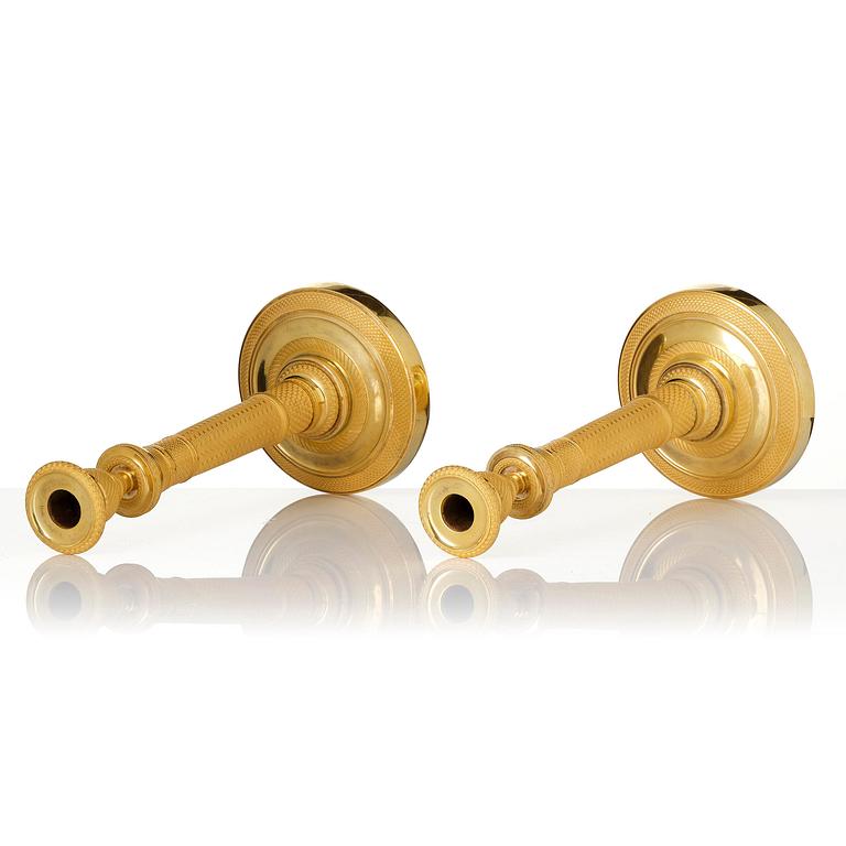 A pair of French Empire gilt-bronze candlesticks, early 19th century.