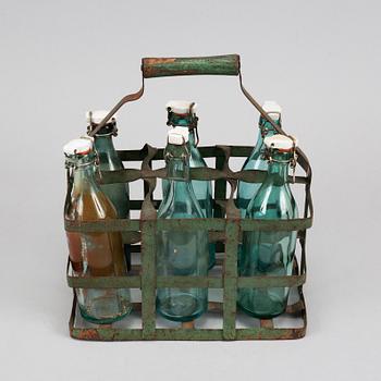 A 19th century tinplate bottle stand with six glass bottles.