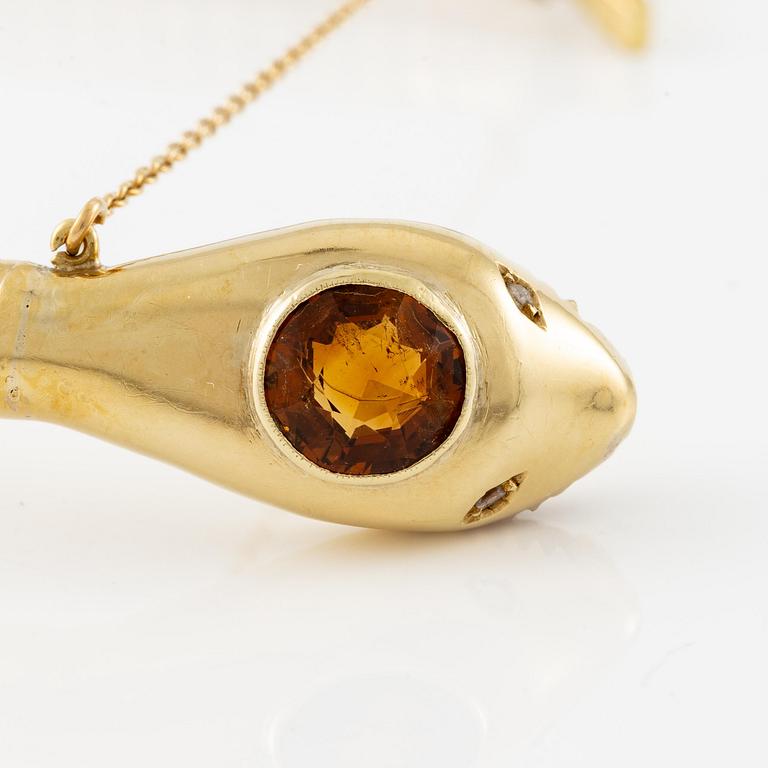 A bracelet in the shape of a serpent in 18K gold with a faceted citrine and rose-cut diamonds.