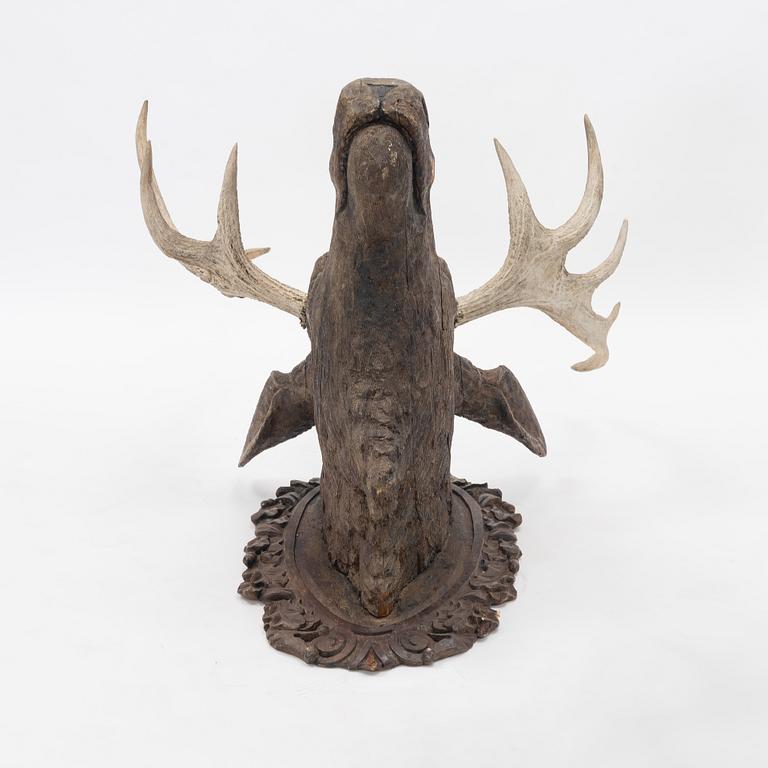 A wooden moose head with horns.