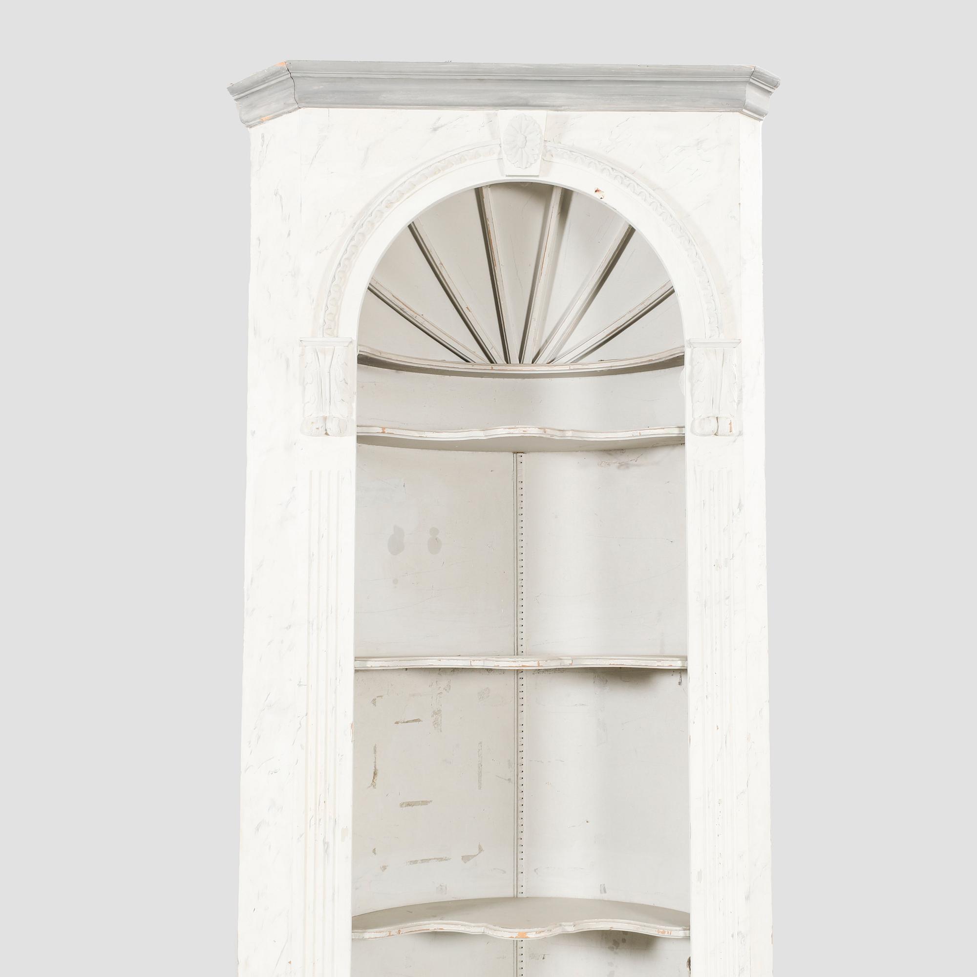 A painted Louis XVI style wallmounted corner cabinet.