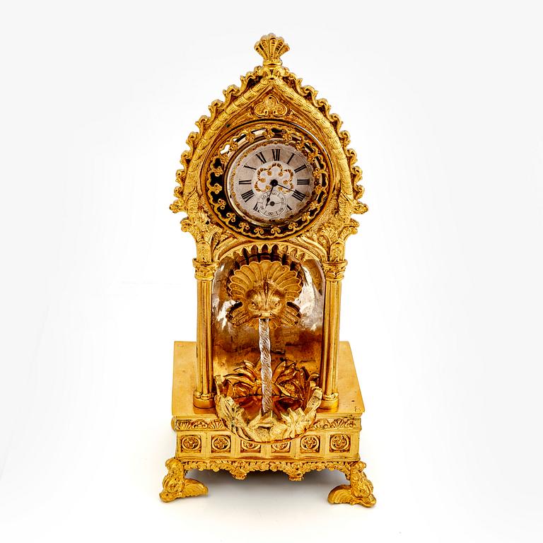 A mid 1800s gilded bronze pocket watch stand and pocket watch.