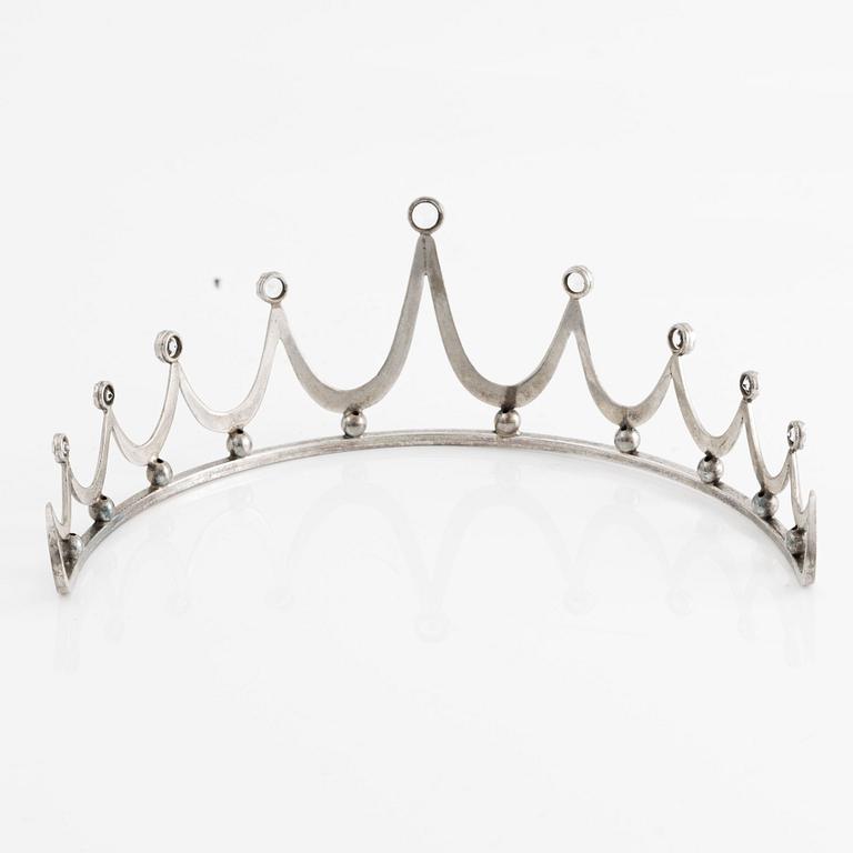 Tiara in silver with white stones.