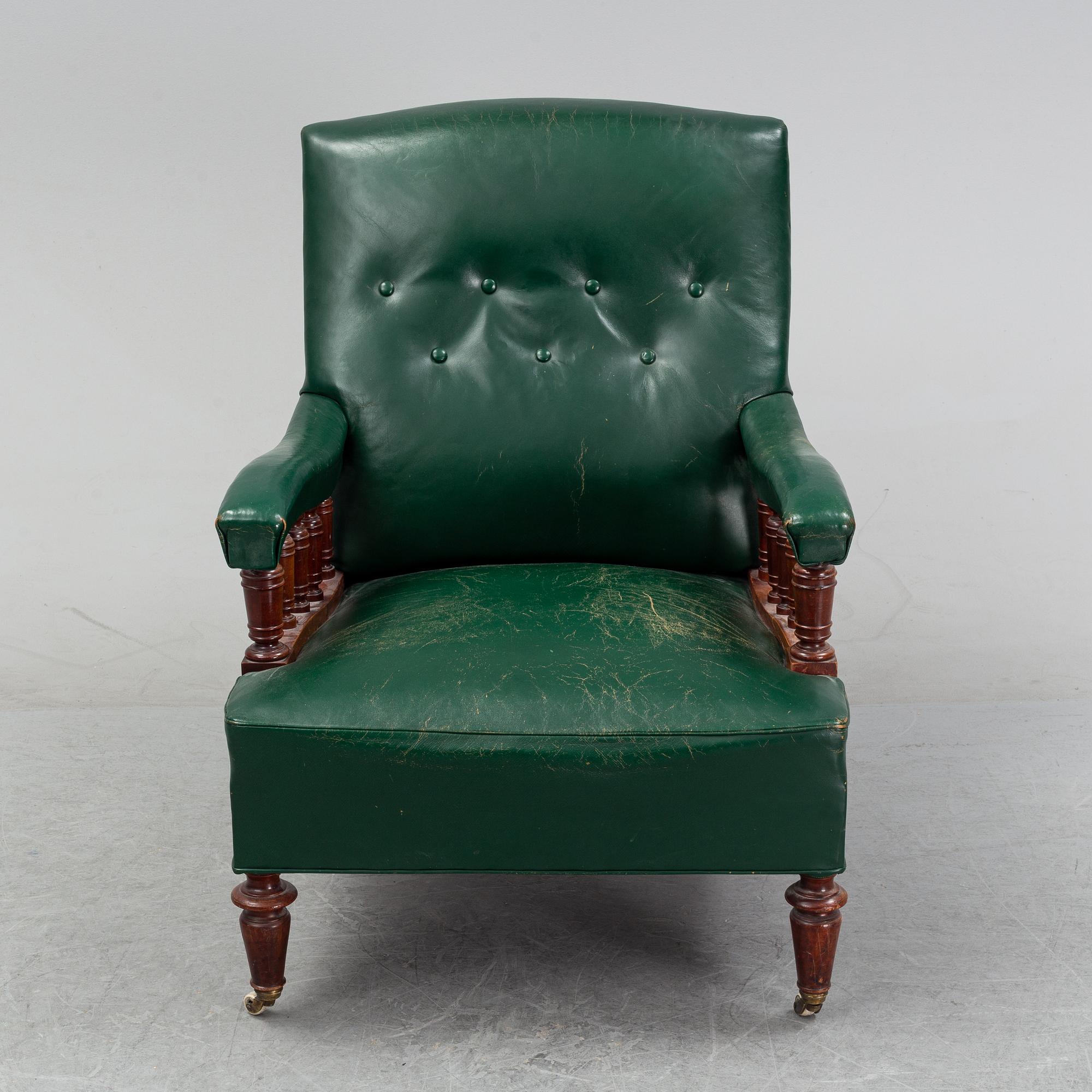 An early 20th Century easy chair with leather upholstery.