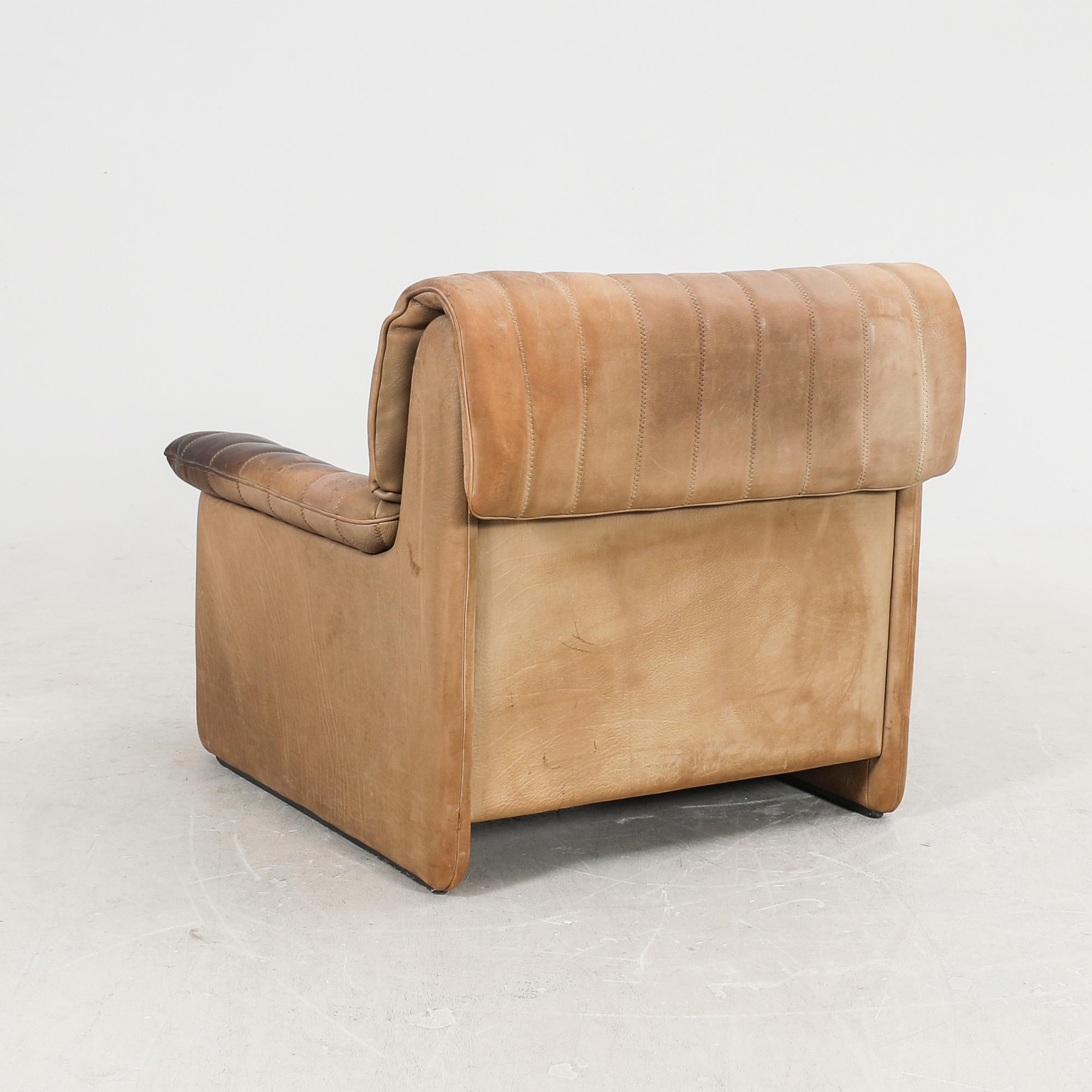 A set of two leather armchairs and a stool by De Sede, Schweiz second half of the 20th century.