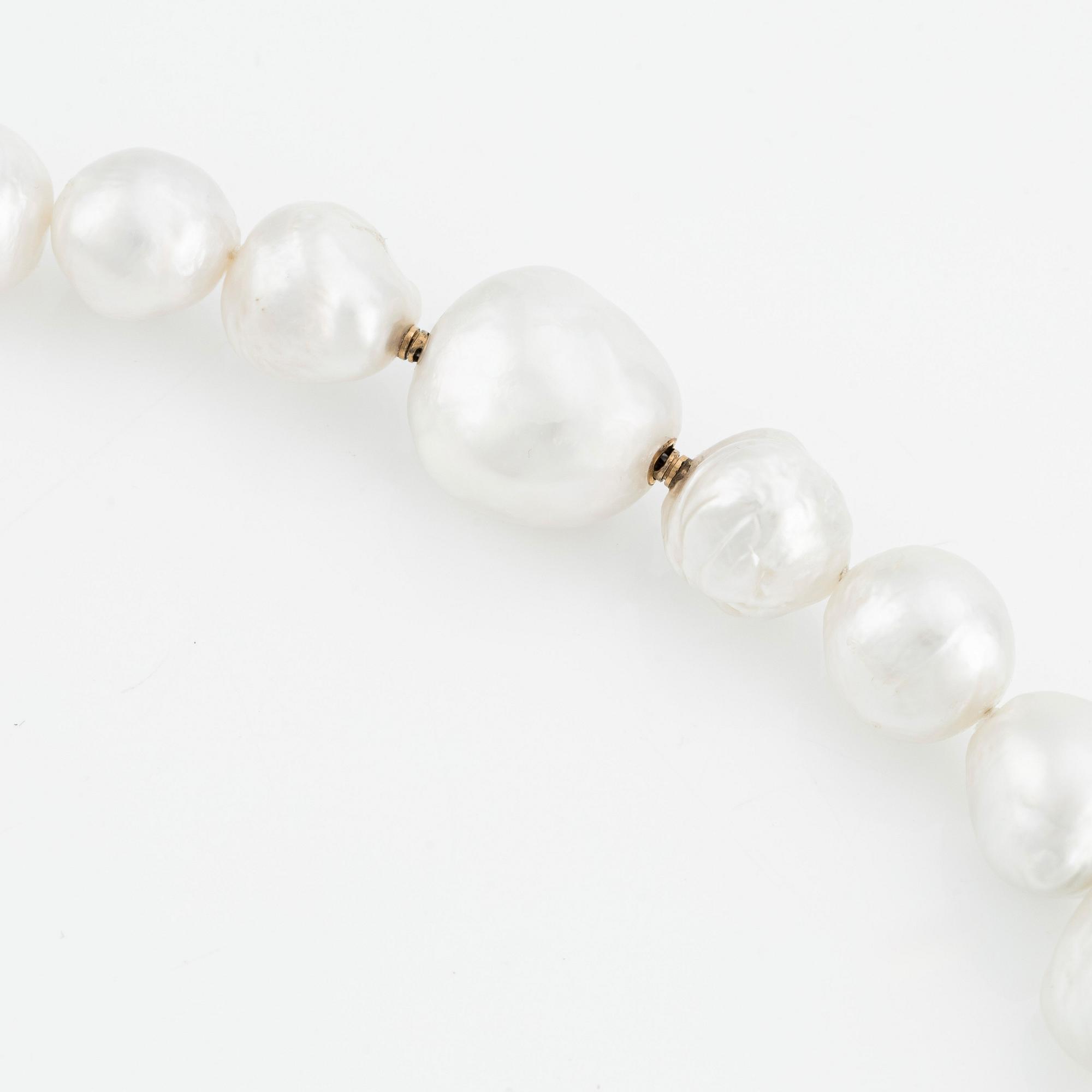 A Gaudy necklace with cultured South Sea pearls, a platinum bracelet, and two clasps.