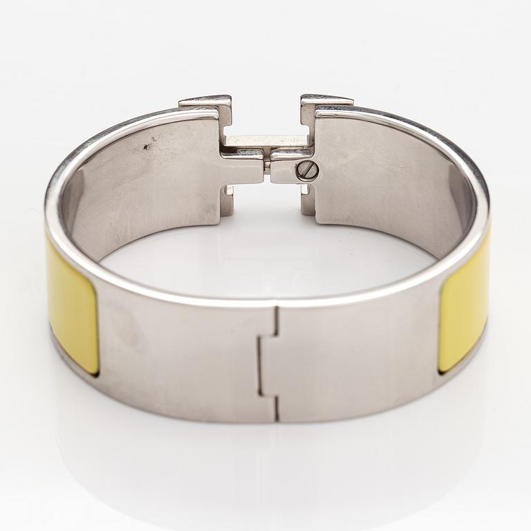 Hermès, A "Click H" bracelet made of metal and yellow enamel. Marked Hermès, ST1105, S, Made in France.
