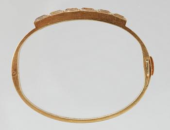 A Wiwen Nilsson 18k gold bangle with facet cut beryls.