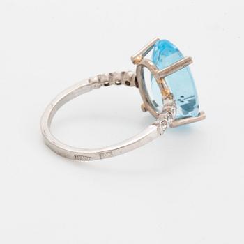 Oval faceted blue topaz and brilliant-cut diamond cocktail ring.