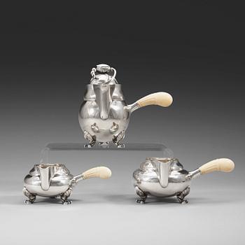 550. A Georg Jensen sterling 'Blossom' set of a lidded chocolate jug and two creamers, Copenhagen 1925-32 and 1933-44.