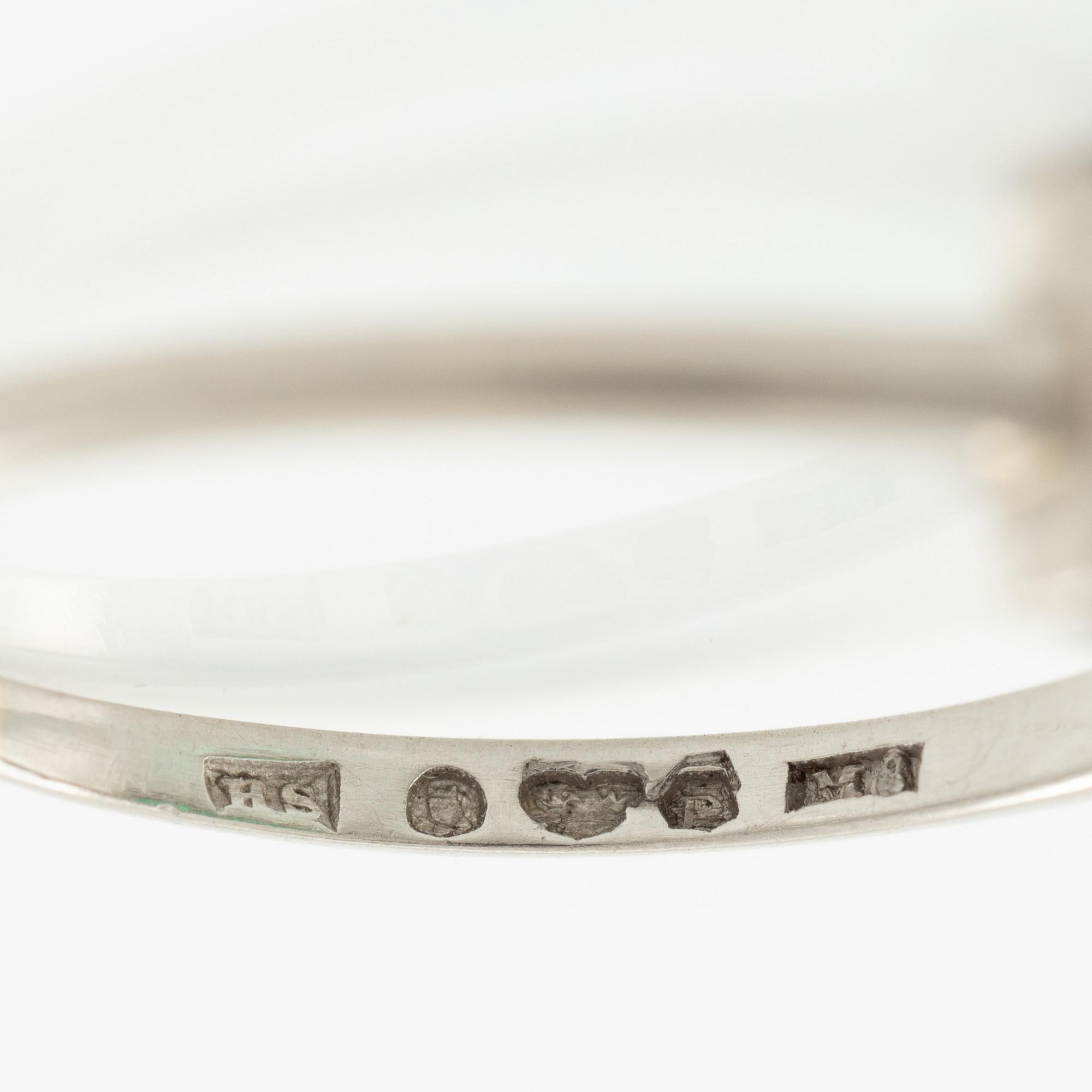 Ring in platinum set with step-cut emeralds and rose-cut diamonds.