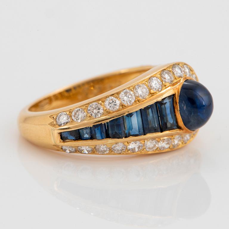 An 18K gold Wempe ring set with sapphires and round brilliant-cut diamonds.