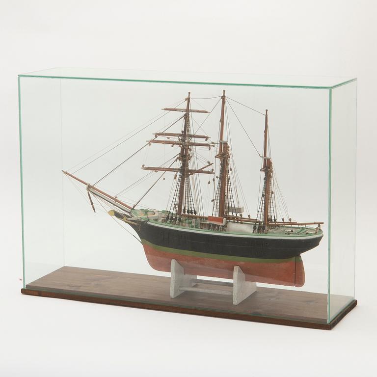 Fartygsmodell, toppsegelskonare, i monter, 1900-tal.