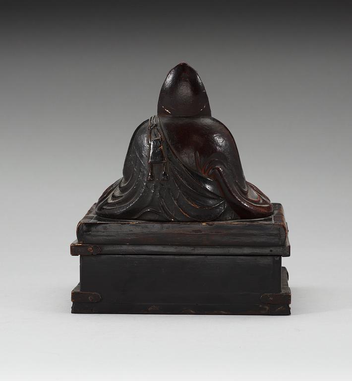 A lacquered wooden Japanese deity on a stand, 19th Century.